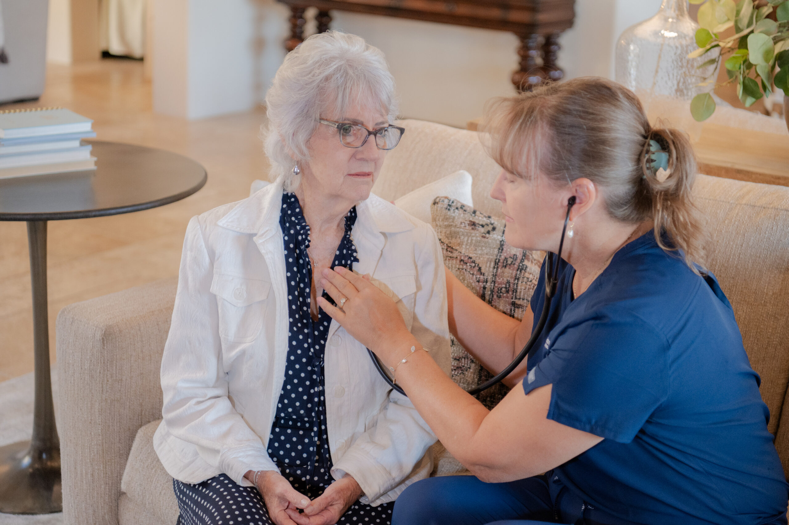 A female caregiver from Total Care Connections checking the vitals of a senior client at home.