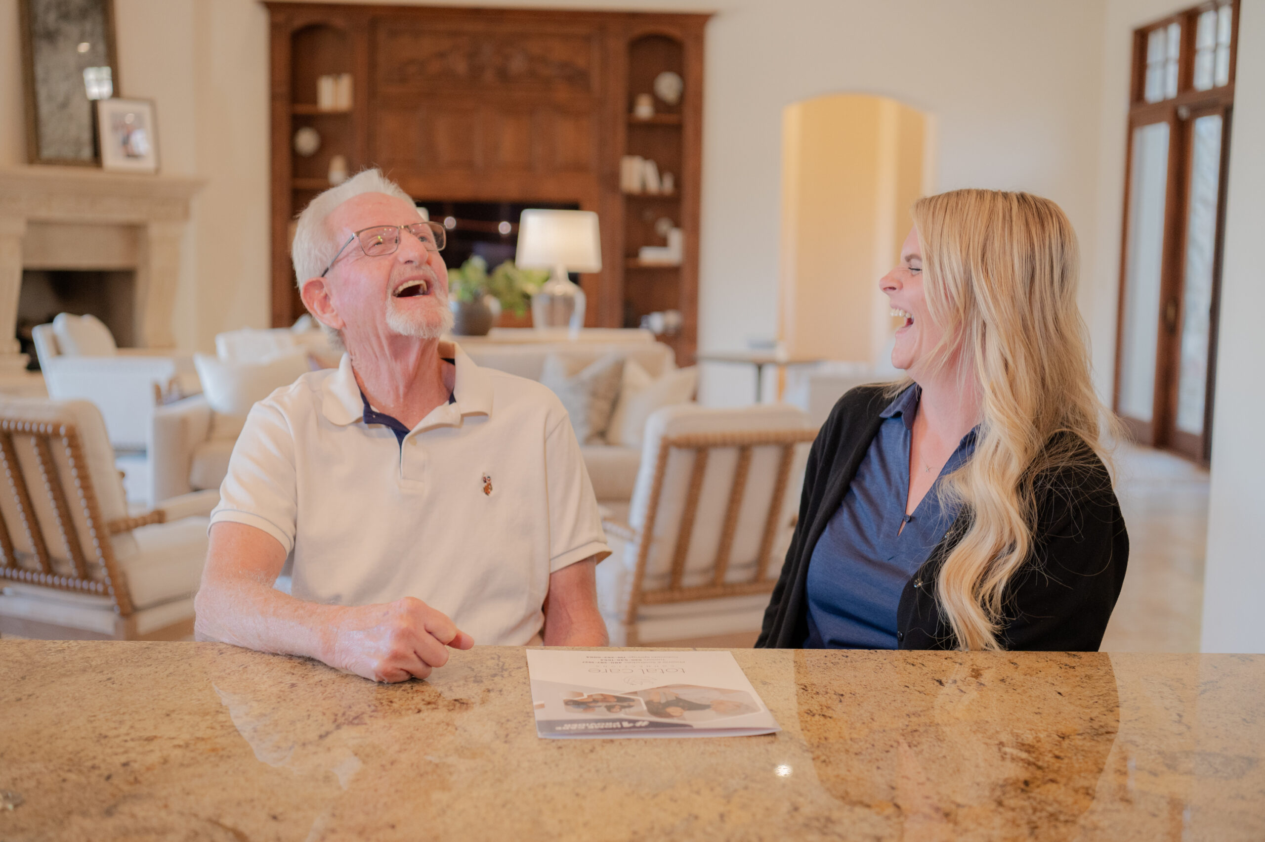 A caregiver from Total Care Connections laughing with a senior client.